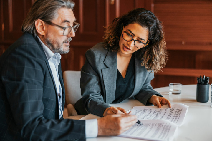 male and female business professionals examing document