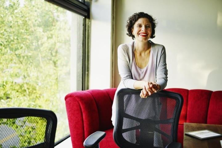 female executive standing behind office chair