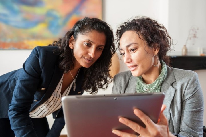 two women looking at a tablet