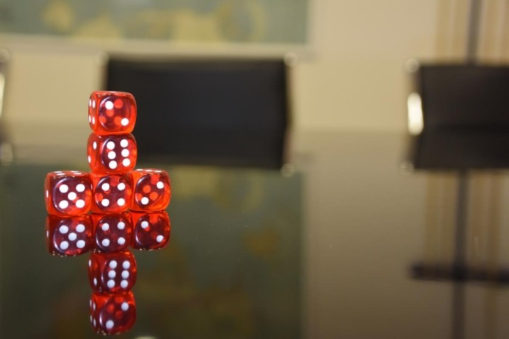 red-dice-stacked-on-a-boardroom-table