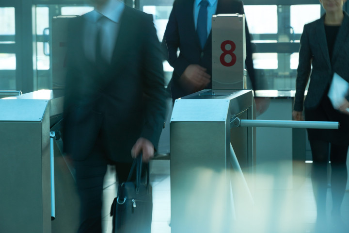 business people coming to work through security