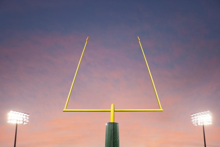 football goalpost and stadium lights against sunset background