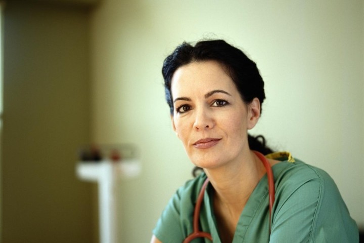 nurse in green scrubs with red stethoscope