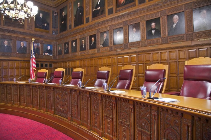 portraiture above carved wood deck in courtroom