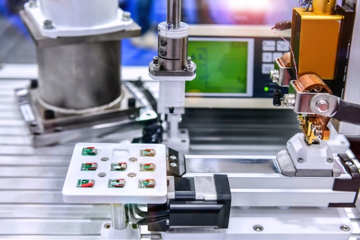 circuit board being assembled by robotic arm
