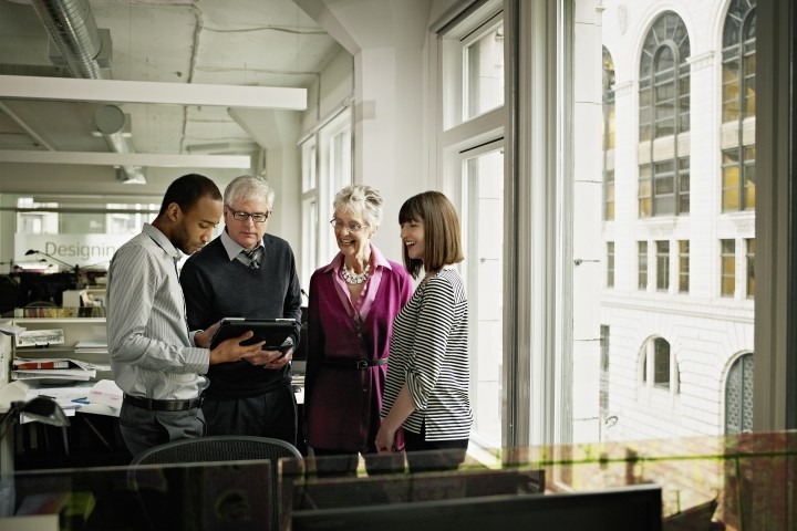 coworkers discussing project on digital tablet