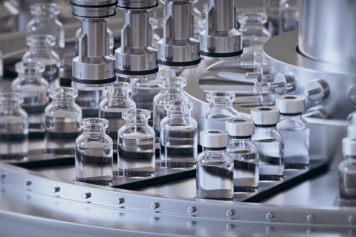 Pharmaceutical manufacture background with glass bottles with clear liquid on automatic conveyor line