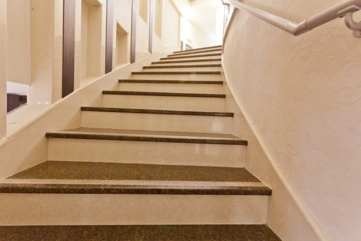 curved marble staircase leading to lighted landing 