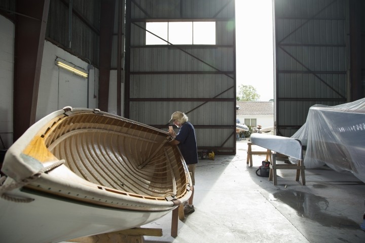 Mature male handcrafting wooden boat