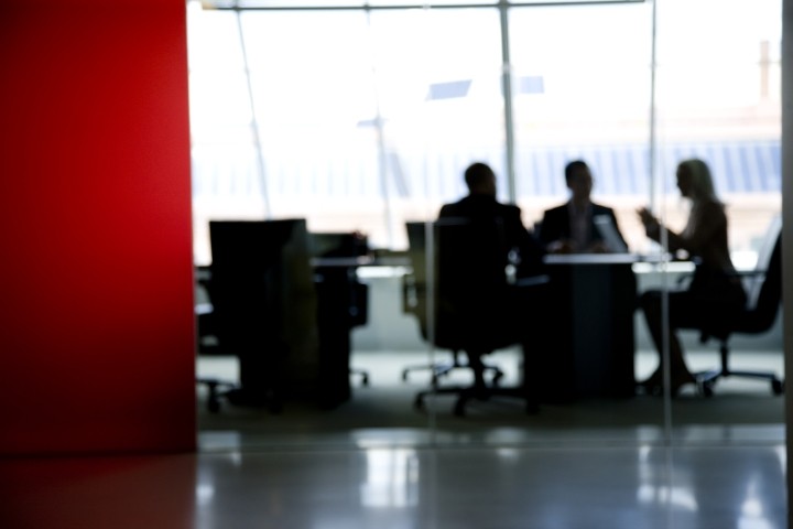 blurred image of three directors meeting in a board room