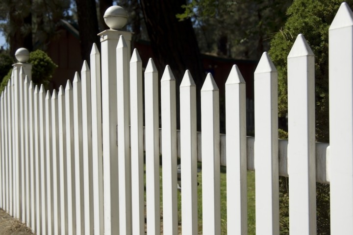 tall white picket fence in suburban yard