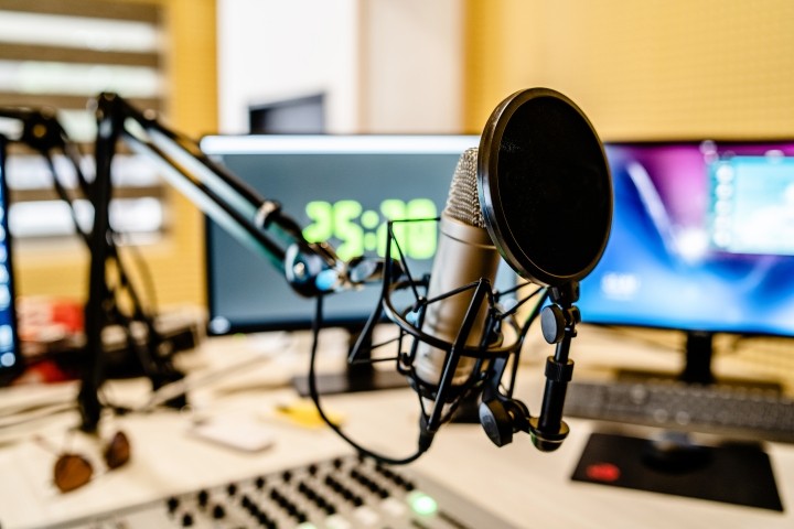 podcast microphone and sound mixer in front of monitors