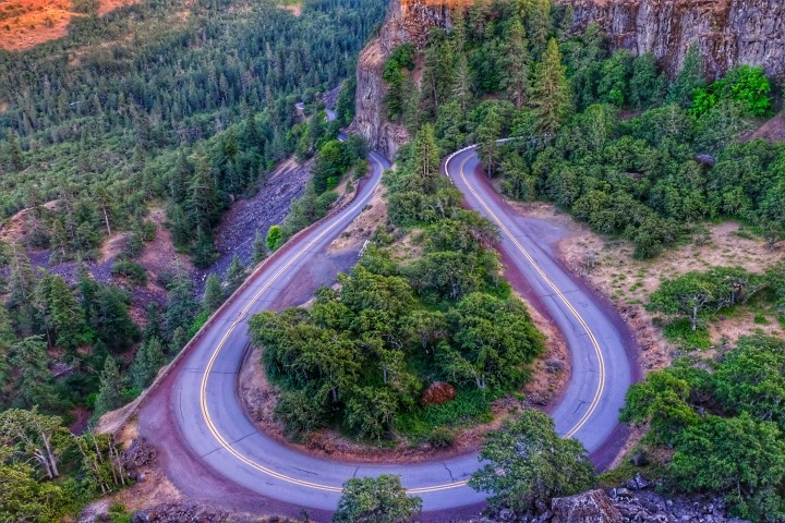aerial view of hairpin turn in the road in a forested area