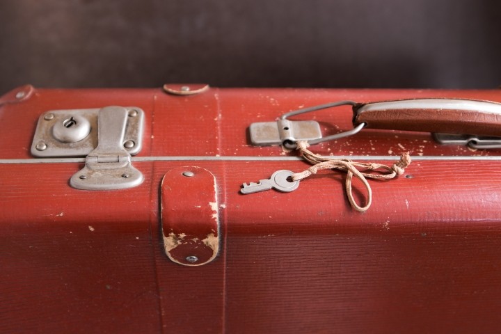 closeup of vintage red suitcase lock and key