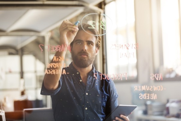 businessman preparing plan on glass wall