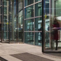 blurred image of people moving through revolving office door