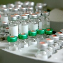 glass vials with green and silver caps in a centrifuge