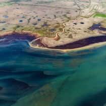 aerial shot of a coastal plain filled with blue ponds
