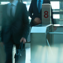 business people coming to work through security