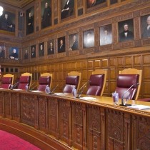 portraiture above carved wood deck in courtroom