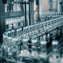 closed glass bottles of upscale vodka transported by line