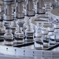 Pharmaceutical manufacture background with glass bottles with clear liquid on automatic conveyor line