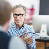 businessman explaining glass model to colleague