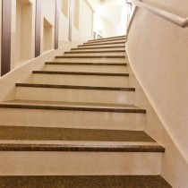 curved marble staircase leading to lighted landing 