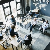 coworkers having informal project meeting in high tech office overhead view