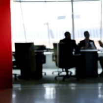 blurred image of three directors meeting in a board room