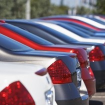 closeup of red white and blue cars on a lot
