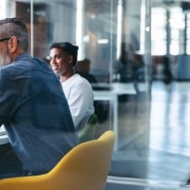 smiling older executive leader at modern table with coworkers